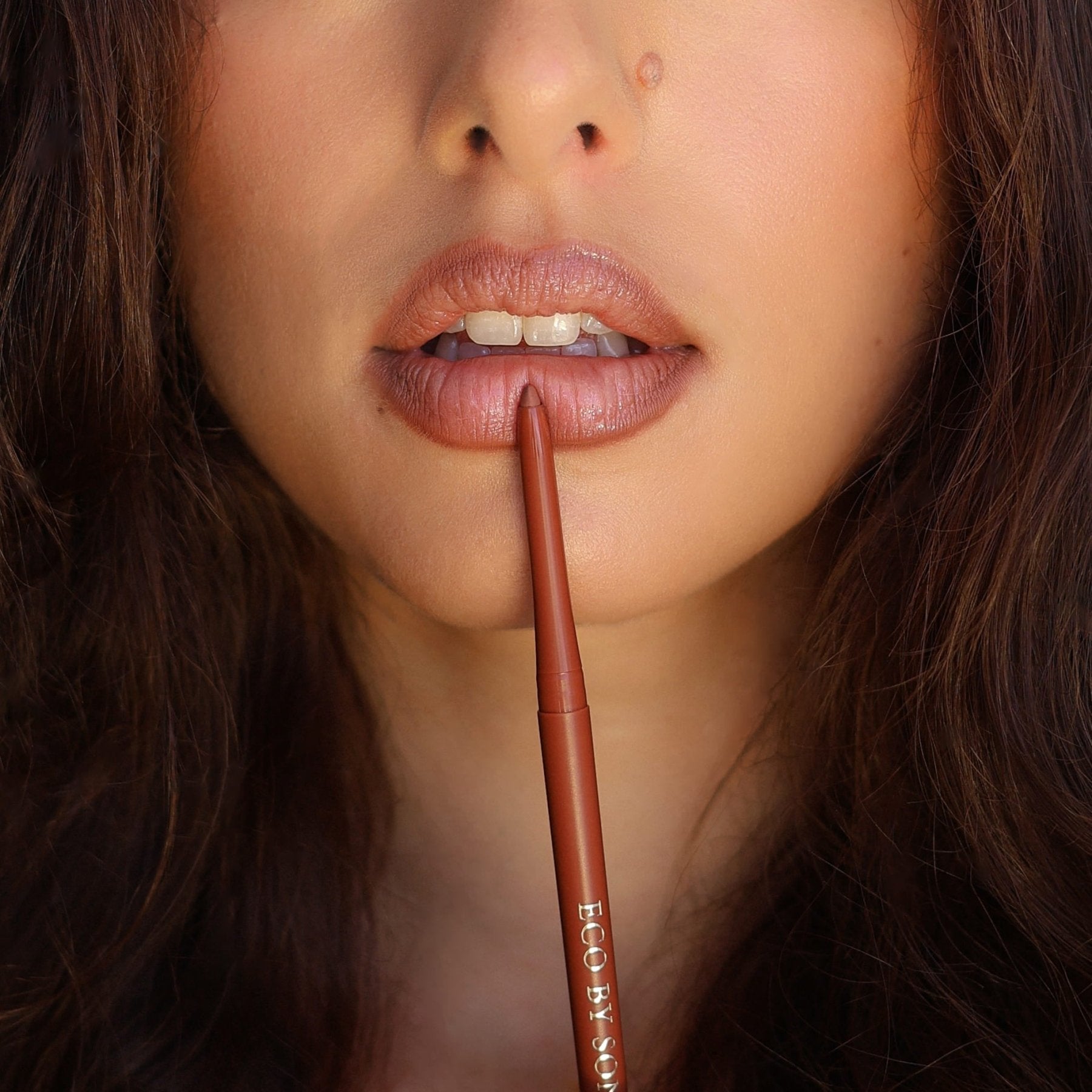 Close-up of a model’s lips holding Eco By Sonya Moody Nude lip liner against her lips.