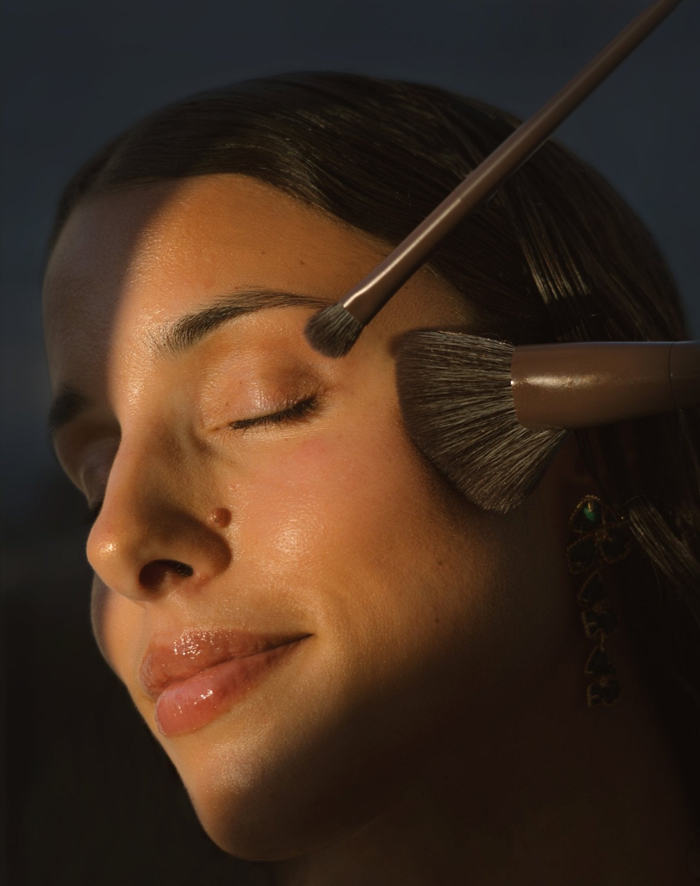 Close-up of a woman's face using 2 of the Eco By Sonya Makeup Brushes.