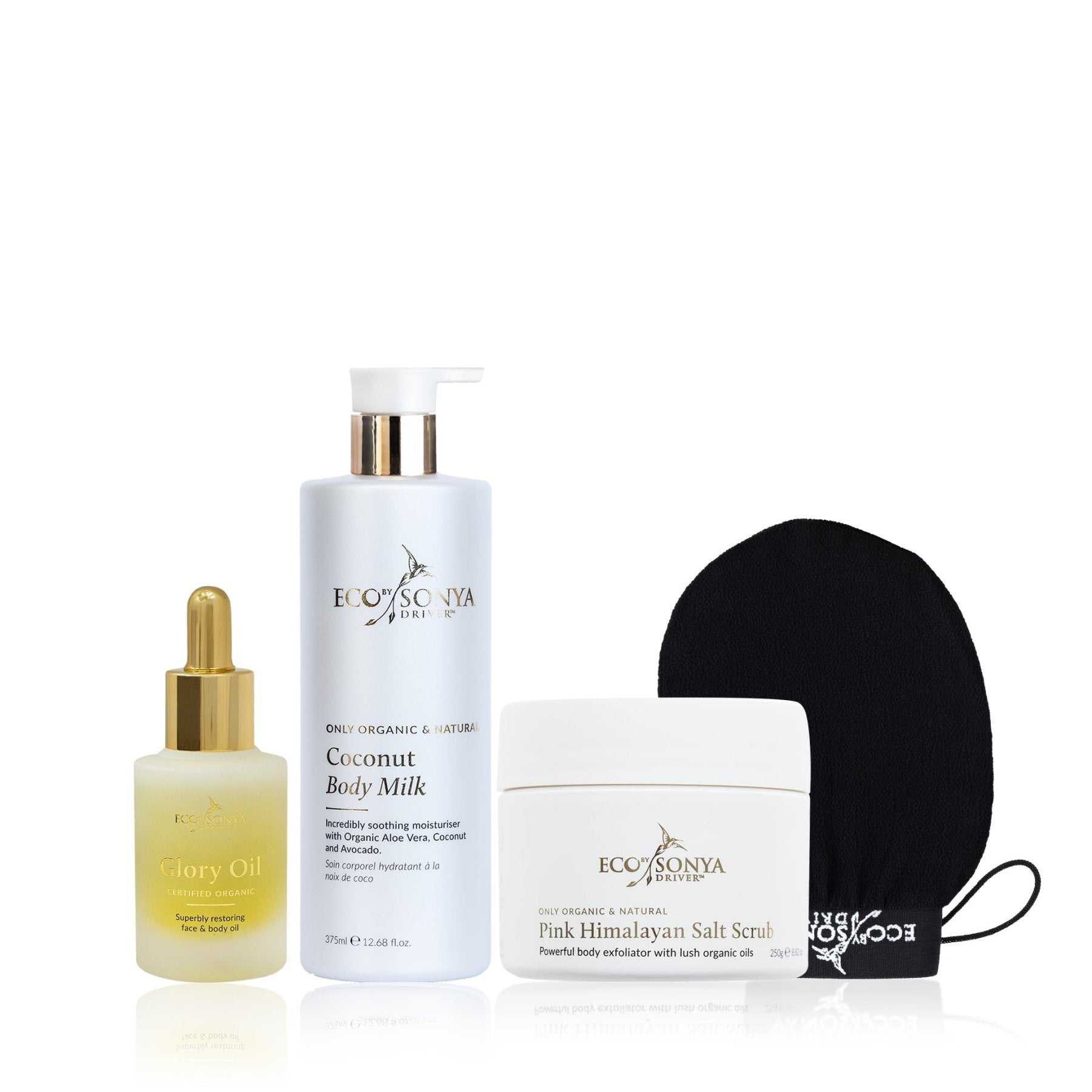 Set of Eco by Sonya skincare products including glory oil, body milk, salt scrub, and mitt on a white background.