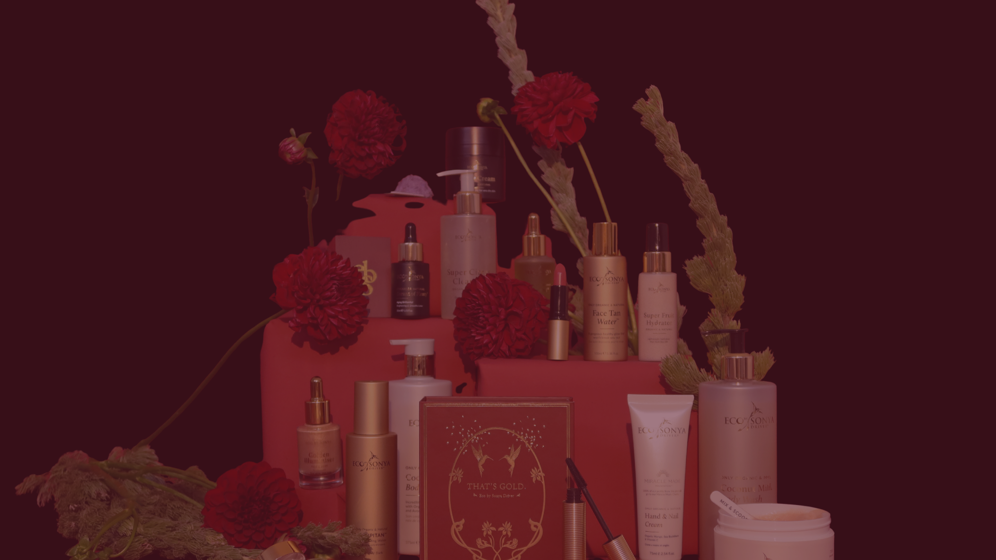 Eco By Sonya Organic products with Christmas details on a dark red background